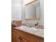 Well-lit bathroom featuring a framed mirror, granite countertop, and wicker basket at 7474 E Arkansas Ave # 17-07, Denver, CO 80231