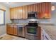 Efficient kitchen layout with stainless steel appliances, light wood cabinetry, and easy-to-clean tile flooring at 7474 E Arkansas Ave # 17-07, Denver, CO 80231