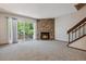 Bright living room showcasing a stone fireplace, large sliding doors to a backyard view, and cozy carpeting at 7474 E Arkansas Ave # 17-07, Denver, CO 80231