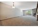 Large living room featuring neutral carpeting, a stone fireplace, and sliding glass doors to a backyard view at 7474 E Arkansas Ave # 17-07, Denver, CO 80231