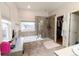 Bathroom features a soaking tub, walk-in shower, walk-in closet, and vanity area at 9844 Norfolk St, Commerce City, CO 80022