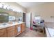 Bathroom with double vanity, makeup desk, and window at 9844 Norfolk St, Commerce City, CO 80022