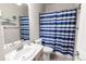 Bathroom with a white vanity and blue striped shower curtain at 9844 Norfolk St, Commerce City, CO 80022