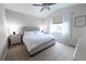 Bedroom featuring vaulted ceiling, window with blinds, and tufted headboard on bed at 9844 Norfolk St, Commerce City, CO 80022