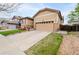 Inviting home exterior showcasing a two-car garage, stone accents, and landscaped front yard at 9844 Norfolk St, Commerce City, CO 80022