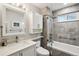 Modern bathroom featuring sleek gray tiling, a glass-enclosed tub, and a floating vanity at 742 Mockingbird Ln, Brighton, CO 80601
