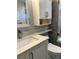 Updated bathroom with a modern vanity, marble countertops and tiled shower and storage at 742 Mockingbird Ln, Brighton, CO 80601