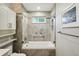 Modern bathroom features a glass enclosed tub, gray tile and white vanity at 742 Mockingbird Ln, Brighton, CO 80601