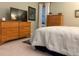 Well-lit bedroom with two dressers, plush carpeting, and a comfortable queen-size bed at 742 Mockingbird Ln, Brighton, CO 80601