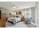 Cozy bedroom with a queen-size bed, ceiling fan, dresser, and sitting area at 742 Mockingbird Ln, Brighton, CO 80601