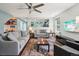 Open concept living room with stylish furnishings, a modern ceiling fan, and a partial view of the kitchen at 742 Mockingbird Ln, Brighton, CO 80601