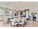 Modern dining area with a stylish chandelier, kitchen with island seating, and adjacent access to a private office at 1768 Peak Loop, Broomfield, CO 80023