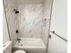 A stunning bathroom showcasing a shower over bath and marble-patterned tile, creating a spa-like oasis at 9255 E Lehigh # 213, Denver, CO 80237