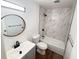 Modern bathroom featuring a round mirror, a sleek sink, and a luxurious shower with marble-patterned tile at 9255 E Lehigh # 213, Denver, CO 80237