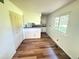 Bright kitchen featuring modern flooring, white cabinetry, and views into the dining area at 9255 E Lehigh # 213, Denver, CO 80237