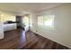 Inviting living room with hardwood floors, large window, and partial view of the kitchen, perfect for entertaining at 9255 E Lehigh # 213, Denver, CO 80237