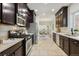 Spacious kitchen featuring stainless appliances and dark cabinets with a view into the dining room at 2738 W 38Th Ave, Denver, CO 80211
