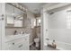 Bright bathroom offers shower over tub with white tiled wall and storage shelves at 3024 S Sherman St, Englewood, CO 80113