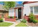 Charming home's front entry features a dark wood door, brick accents, and a welcoming Hello doormat at 3024 S Sherman St, Englewood, CO 80113