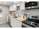 Bright kitchen with white cabinetry, stainless steel appliances, wood countertops, and herringbone backsplash at 3024 S Sherman St, Englewood, CO 80113