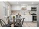 Eat-in kitchen features stainless appliances, white cabinets, butcher block counters, and a modern glass table at 3024 S Sherman St, Englewood, CO 80113