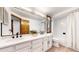 Bright bathroom with white cabinets, double sinks, large mirror, and shower with white tile surround at 4998 W 101St Ave, Westminster, CO 80031