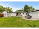 Large backyard with lush green lawn, patio with umbrella table, and a detached garage, perfect for outdoor living at 5369 S Sherman St, Littleton, CO 80121