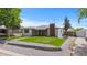 A single-story home featuring a brick chimney, covered porch, and a well-maintained lawn and detached garage at 5369 S Sherman St, Littleton, CO 80121