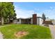 Quaint single-story home featuring a brick chimney, inviting front porch, and green lawn at 5369 S Sherman St, Littleton, CO 80121