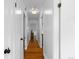 Clean hallway with neutral paint, contrasting doors, and warm hardwood floors at 5369 S Sherman St, Littleton, CO 80121