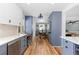 Modern kitchen with blue cabinets, stainless steel appliances, and wood flooring that overlooks the dining room at 5369 S Sherman St, Littleton, CO 80121