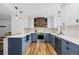 Modern kitchen with stylish blue and white cabinets, stainless steel appliances, and wood flooring at 5369 S Sherman St, Littleton, CO 80121