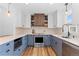 Modern kitchen with stylish blue and white cabinets, stainless steel appliances, and wood flooring at 5369 S Sherman St, Littleton, CO 80121