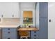 Modern kitchen with built in desk area and blue cabinets, white countertops, and stainless steel appliances at 5369 S Sherman St, Littleton, CO 80121