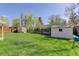 Expansive backyard with lush green grass and two storage sheds, enclosed by a wooden fence at 6280 Quay St, Arvada, CO 80003