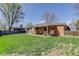 Brick home featuring a spacious backyard with a covered patio and well-maintained lawn at 6280 Quay St, Arvada, CO 80003