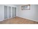 Bedroom features hardwood floors, natural light, and built in closet with sliding panel doors at 6280 Quay St, Arvada, CO 80003