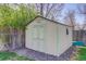 Backyard storage shed featuring double doors, a window, and close proximity to a wooden fence at 6280 Quay St, Arvada, CO 80003