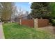Exterior view of a home with a gray facade, green lawn, a tall chimney, and a wooden fence at 1972 S Carr St, Lakewood, CO 80227