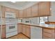 Bright kitchen features white appliances, light wood cabinets, and wood-look flooring at 1972 S Carr St, Lakewood, CO 80227