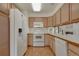 Bright kitchen featuring white appliances, light wood cabinets, and wood-look flooring at 1972 S Carr St, Lakewood, CO 80227
