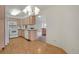 Bright kitchen featuring white appliances, light wood cabinets, wood flooring, and view into living room at 1972 S Carr St, Lakewood, CO 80227