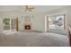 Sunlit living room with a fireplace, large windows, and sliding doors to the deck at 1972 S Carr St, Lakewood, CO 80227