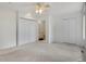 Light filled main bedroom featuring neutral carpeting, ceiling fan, double closets, and access to ensuite bathroom at 1972 S Carr St, Lakewood, CO 80227