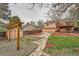 Inviting backyard featuring a wooden pergola, shed, garden beds, and a two-story home with a deck at 18981 E Mercer Dr, Aurora, CO 80013