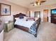 Spacious primary bedroom featuring a tray ceiling, decorative fan, and ensuite bathroom at 620 Coyote Trl, Elizabeth, CO 80107