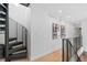 An upper hallway featuring a black spiral staircase, light hardwood floors, and modern art at 3709 Tejon St, Denver, CO 80211