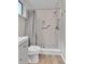 Bright bathroom featuring a tiled shower with a safety bar, new fixtures, and a gray vanity with laminate floors at 9501 W 89Th Cir, Broomfield, CO 80021