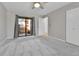 A well-lit bedroom with neutral walls and carpet, a sliding glass door with curtains, and access to the deck at 9501 W 89Th Cir, Broomfield, CO 80021