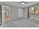 A bedroom with neutral walls and carpet, a window with curtains, and access to the ensuite bath at 9501 W 89Th Cir, Broomfield, CO 80021